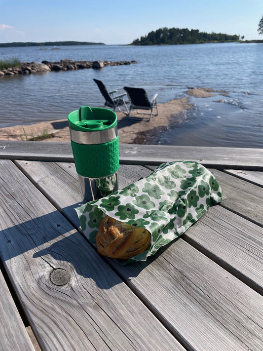 Ekeby bivaxpåse med bullar i, som ligger på en brygga med sjö bakom